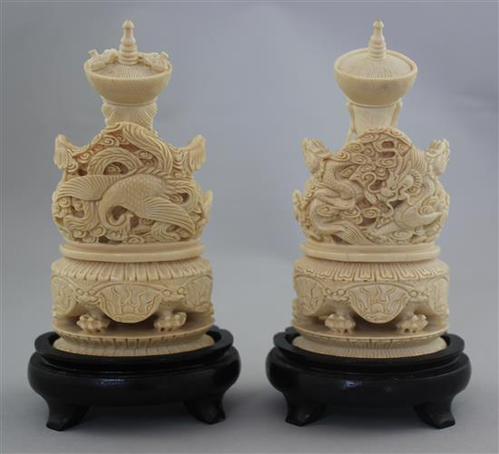 A pair of Chinese ivory seated figures of an emperor and empress, first half 20th century, 13.5cm excl. the wood stands